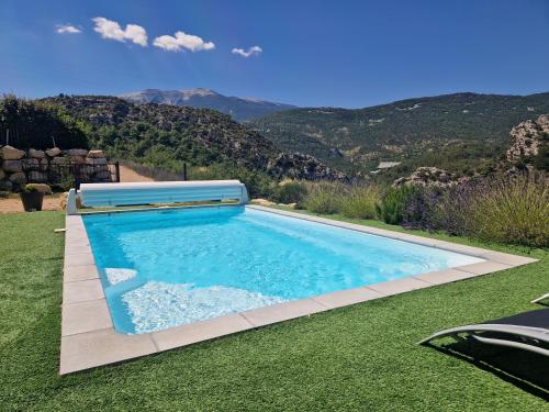 una piscina in un cortile con le montagne sullo sfondo di Les Villas Dorées - Villa Métal face au Mont Ventoux a Plaisians