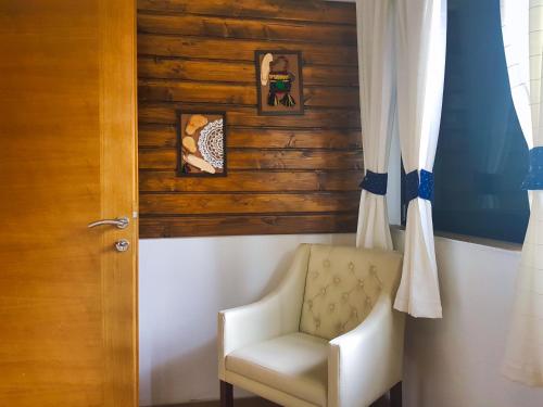 a white chair in a room with a wooden wall at Green Garden Plitvice lakes in Plitvica selo