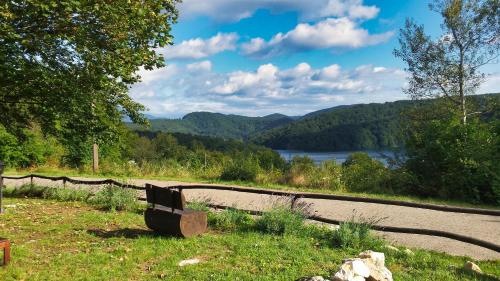a bench sitting on the side of a road with a view at Green Garden Plitvice lakes in Plitvica selo