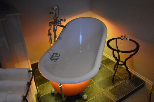 a bath tub in the corner of a room at Long Melford Swan in Long Melford