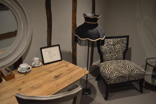 a room with a table and a chair and a dresser at Long Melford Swan in Long Melford