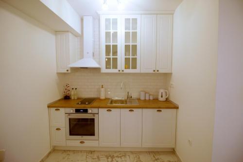 een keuken met witte kasten en een wastafel bij Amellia in Ljubuški