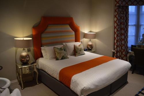a bedroom with a large bed with two lamps at Long Melford Swan in Long Melford