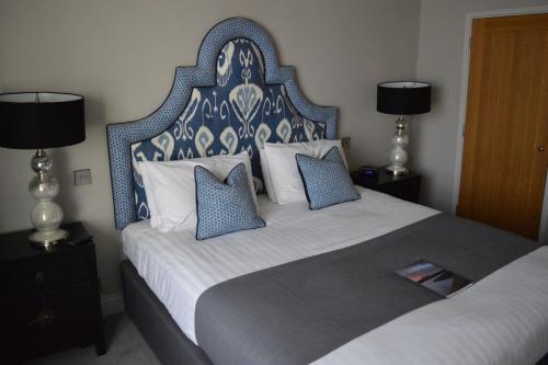 a bedroom with a large bed with blue and white pillows at Long Melford Swan in Long Melford