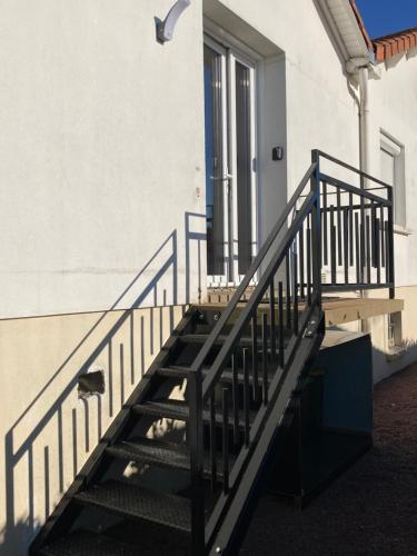 una escalera con barandilla azul junto a un edificio en STUDIO A 20 MIN DU PUY DU FOU, en Mesnard-la-Barotière