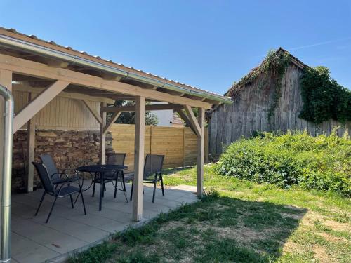 a patio with a table and chairs and a barn at Domek v Podyjí in Lukov