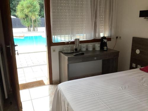 a bedroom with a bed and a desk with a window at la dolce farniente in Biaudos