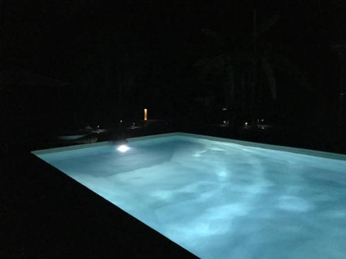 a large blue swimming pool at night at la dolce farniente in Biaudos