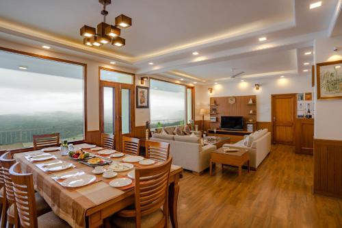 a dining room and living room with a table and chairs at Hostie Mystica-Highest Penthouse with Terrace, Mashobra in Shimla