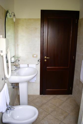 a bathroom with a sink and a toilet and a mirror at Agriturismo L'Arca di Anna Brambilla in Belvedere Marittimo