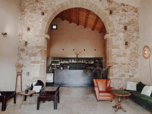 una sala de estar con un bar en una pared de piedra en Case Marianeddi, en Noto