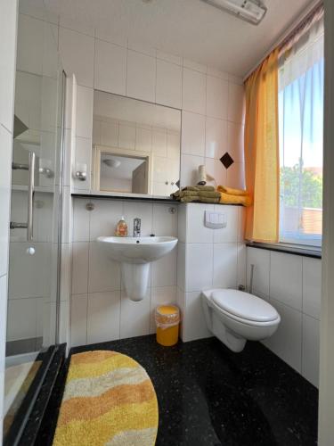 a bathroom with a toilet and a sink at Hotel und Pension Am Burchardikloster in Halberstadt