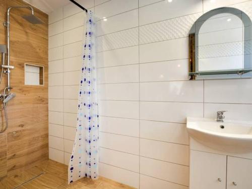 uma casa de banho com uma cortina de chuveiro e um lavatório em Bieszczadzki Szeryf 660-492-682 em Polańczyk