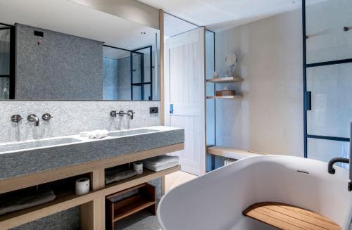 a bathroom with a tub and a large mirror at Casa di Langa in Cerretto Langhe