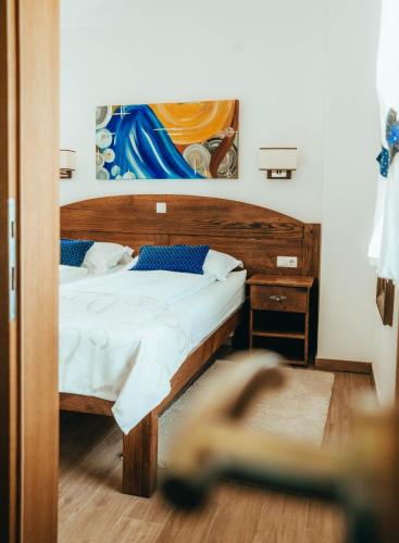 a bedroom with a bed and a painting on the wall at Green Garden Plitvice lakes in Plitvica selo