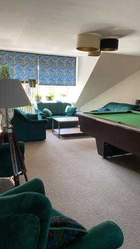 a living room with a pool table and couches at Hotel Wiosna in Rabka