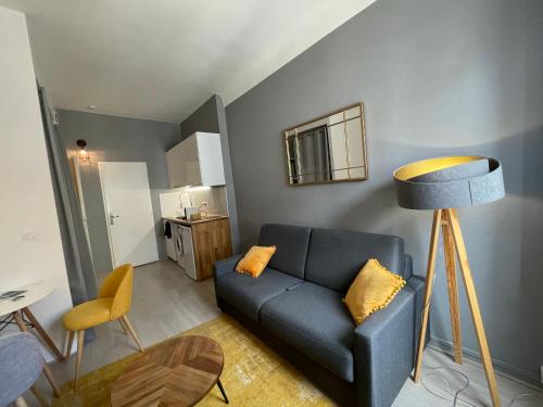 uma sala de estar com um sofá azul e uma mesa em Time Capsule - Studio cosy em Caluire-et-Cuire