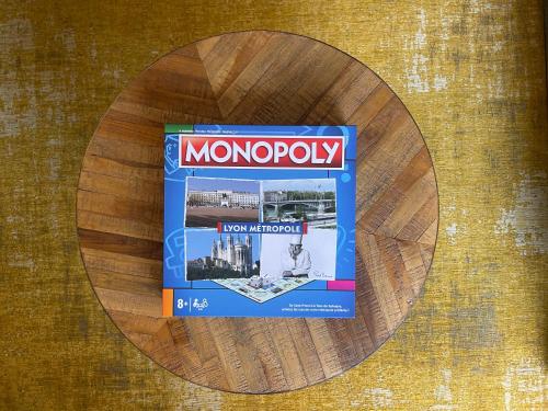 a box of monopoly sitting on top of a wooden table at Time Capsule - Studio cosy in Caluire-et-Cuire