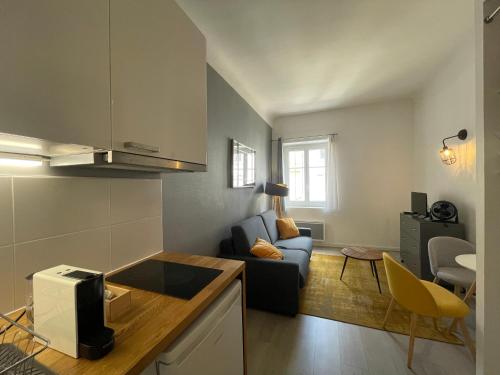 a kitchen and living room with a couch and a table at Time Capsule - Studio cosy in Caluire-et-Cuire