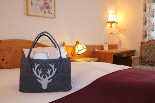 a black and white bag sitting on top of a bed at Landhotel Hubertus in Unterelsbach