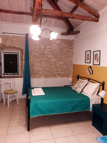 a bedroom with a green bed and a tv at Vila kavalina Leukada Kavalos in Asprogerakata