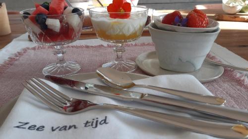 a table with utensils and desserts on a table at Zee-van-Tijd in Oudenburg