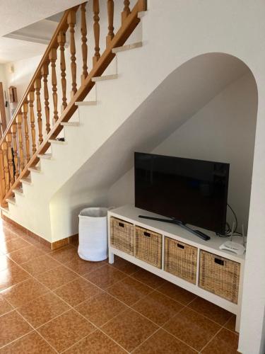 a living room with a tv and a staircase at Casa Elisa 3 bedrooms 2 bathrooms 4 airco's shared pool in Alcossebre