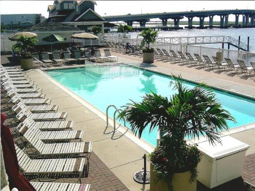 een groot zwembad met stoelen en een brug bij Pier 4 Hotel in Somers Point