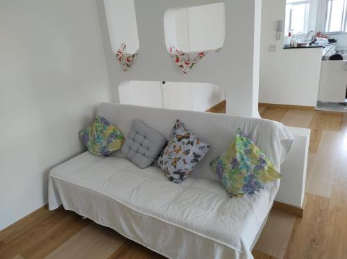 um sofá branco com almofadas na sala de estar em Vista ao Mar em Santos