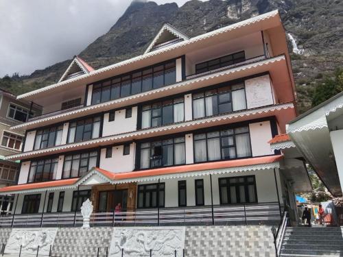 a large building with a mountain in the background at Rufina Lachung Kunga in Lachung