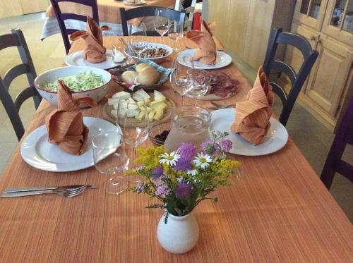 B&B La Marmotta في ماليه: طاولة عليها أطباق من الطعام والزهور