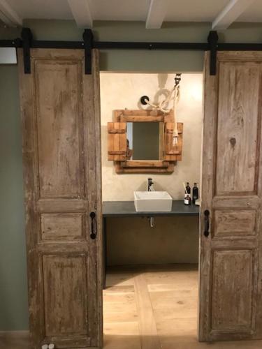 a bathroom with a sink and an open door at Ratatouille in Mayrinhac-Lentour