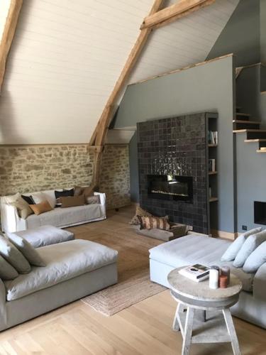 a living room with white furniture and a fireplace at Ratatouille in Mayrinhac-Lentour