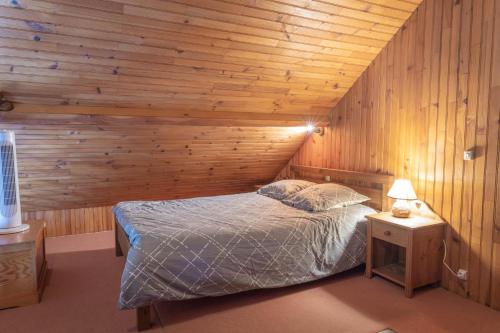 une chambre avec un lit et un mur en bois dans l'établissement Domaine de karoli, à Barneville-sur-Seine