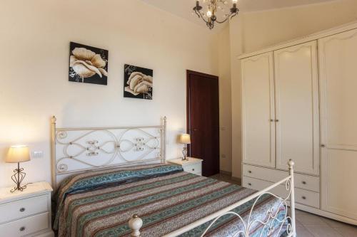 a bedroom with a bed and two night stands and two lamps at Villa Litoranea Santa Margherita di Pula in Domus de Maria