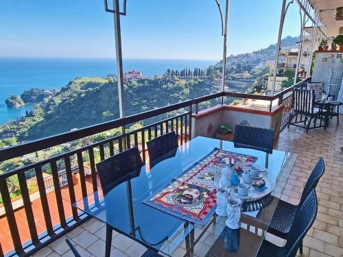 a table on a balcony with a view of the ocean at Little Paradise in Taormina