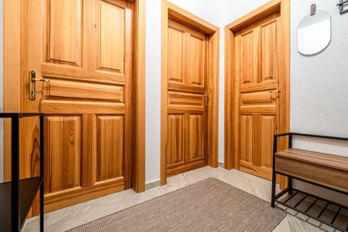 a hallway with wooden doors and a bench at Apartment Harmony - Tatranska Lomnica, Javorinka in Tatranská Lomnica