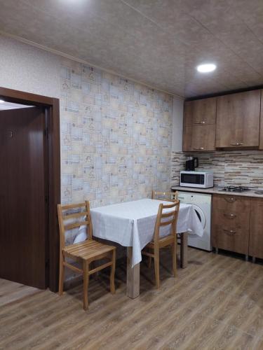 una cucina con tavolo, sedie e microonde di Sesilia a Kazbegi