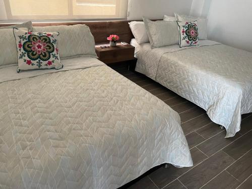 two beds sitting next to each other in a bedroom at Lugar perfecto para ti a solo 300 metros de la playa in Gaira