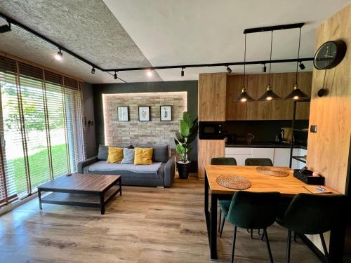 Loft Klonowa - Apartament z garażem في كيلسي: غرفة معيشة مع طاولة وأريكة