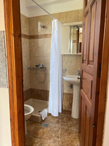 een badkamer met een douche, een toilet en een wastafel bij Molyvos Stars Apartments in Mithimna