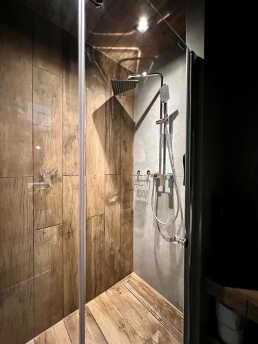 a shower with a glass door in a bathroom at Loft Klonowa - Apartament z garażem in Kielce