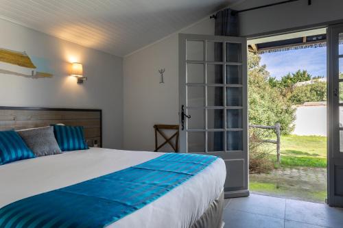 a bedroom with a bed and a sliding glass door at Hotel Mas Des Barres in Saintes-Maries-de-la-Mer
