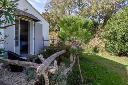 a house with a bench and a tree in the yard at Hotel Mas Des Barres in Saintes-Maries-de-la-Mer