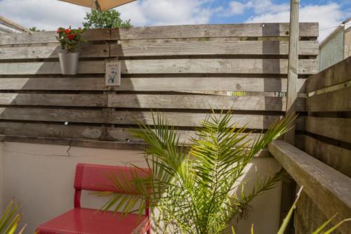a red bench sitting next to a wooden fence at Sydney Wharf House in Bath