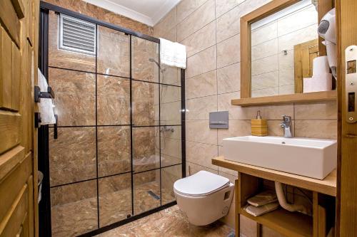 a bathroom with a toilet and a sink and a shower at Dimora Boemo Hotel in Didim