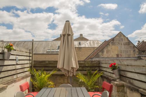 an umbrella sitting on a table on a balcony at Sydney Wharf House in Bath