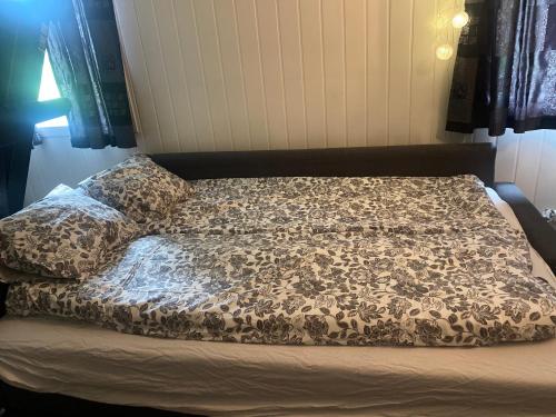 1 cama con edredón y almohadas en Mona en Trondheim