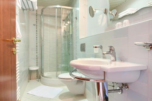 a bathroom with a sink and a toilet and a shower at Hotel Kanajt in Punat