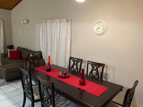 a dining room with a table and chairs with a red table cloth at Devine Stay- Margate in Margate